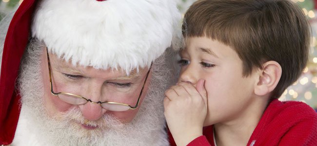 Niño hablando en secreto a Papá Noel