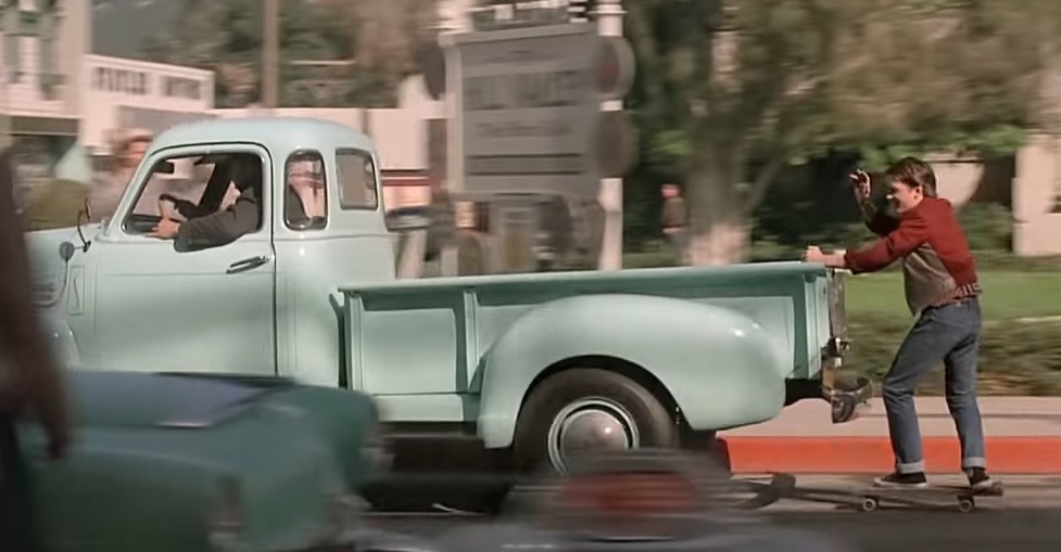 Marty McFly en monopatín agarrado a una furgoneta (película Regreso al Futuro)