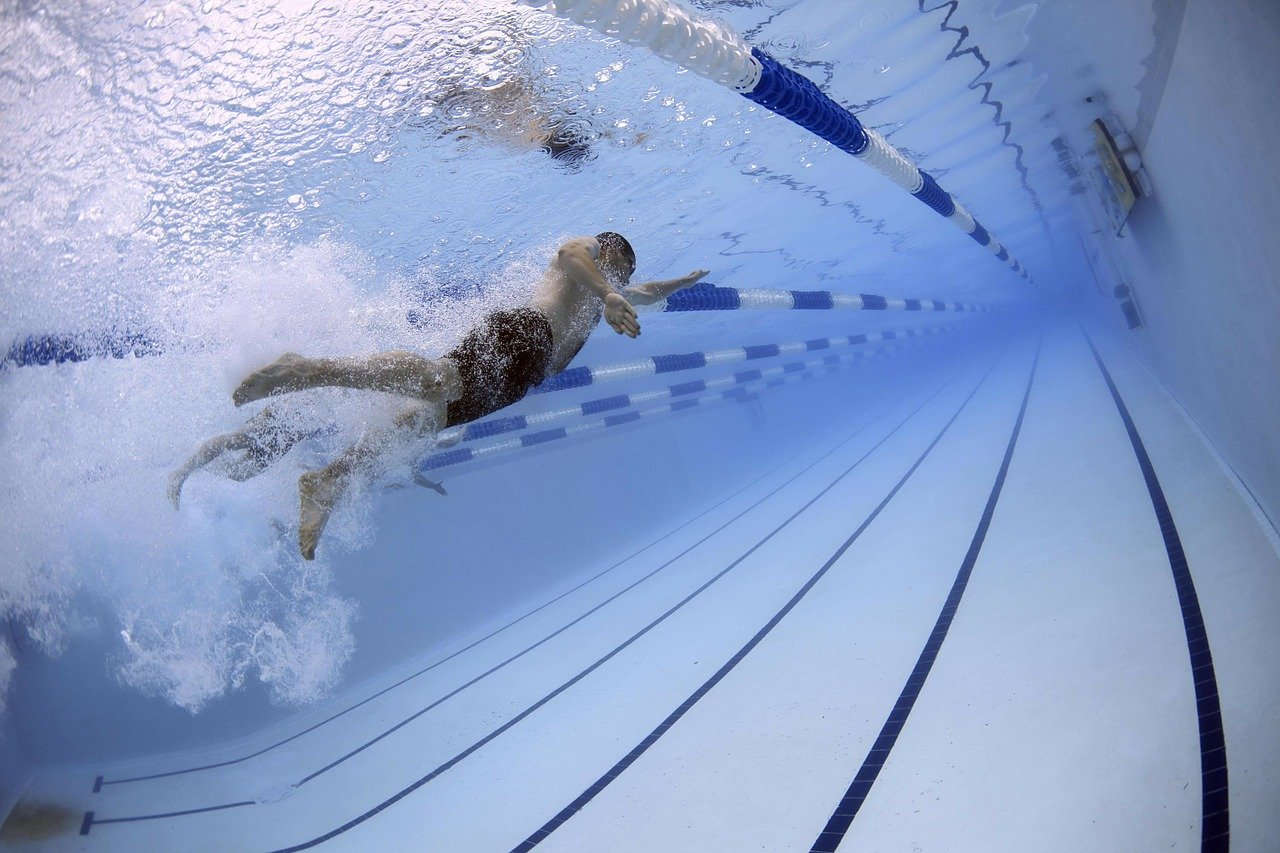 Nadador en una piscina olímpica, visto desde debajo del agua