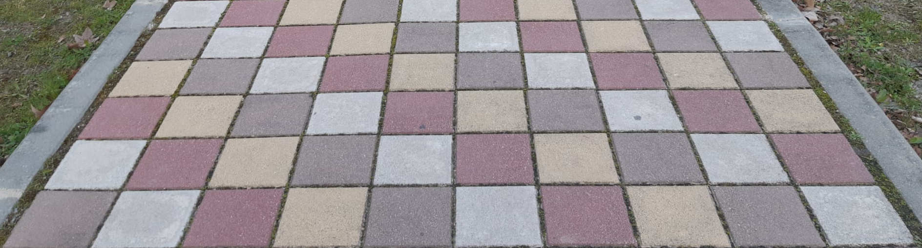 Camino para peatones con losetas de tres colores en diagonal.